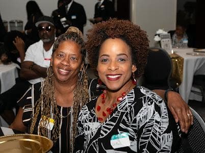 Two guests pose together at the anniversary dinner.
