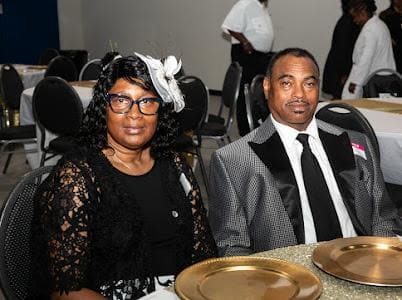 Guests seated at a table set with gold chargers.