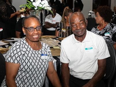 Two guests smile at their table during the anniversary dinner.