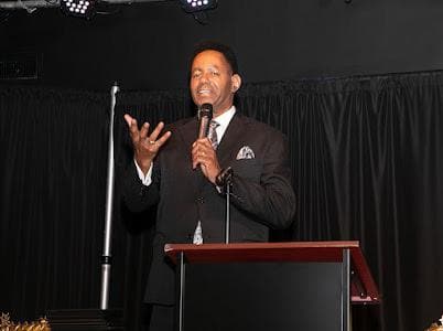 A speaker addresses the audience with a microphone.