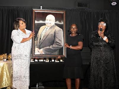 Women present a framed portrait during a tribute.