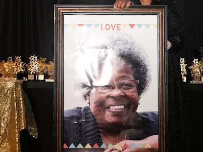A framed portrait is displayed during a tribute.