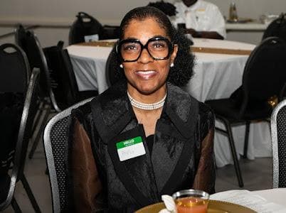 A guest smiles at her table.