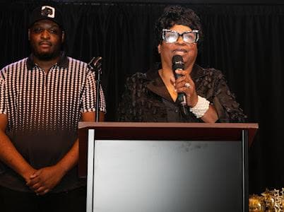 A speaker addresses guests at the podium.