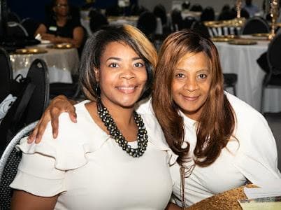 Two guests pose together at the celebration.