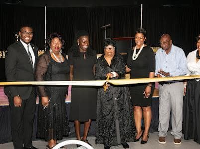 The ribbon is cut at Miracle Mission's 20th anniversary celebration as leaders and guests look on.