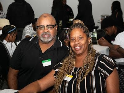 Two guests smile at their table at the anniversary celebration.