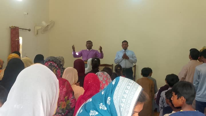 Women and children listen to a speaker at a gathering in Pakistan.