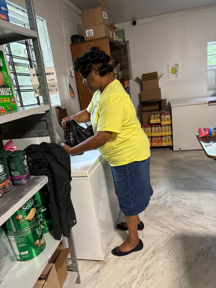 A volunteer organizes donated items in the storeroom.
