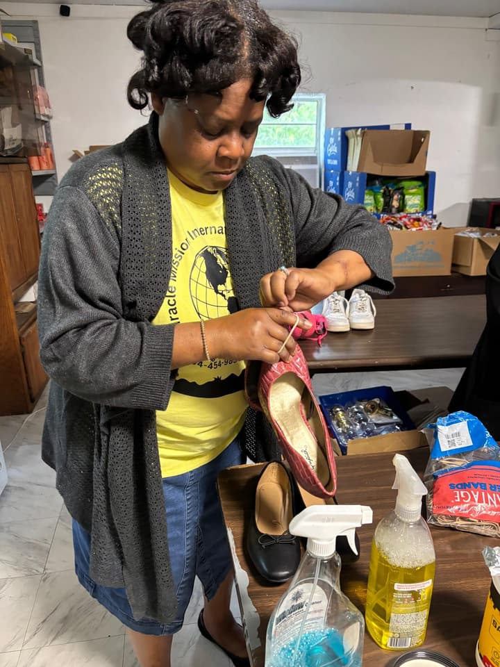 A volunteer inspects a donated shoe before it goes to the clothing closet.